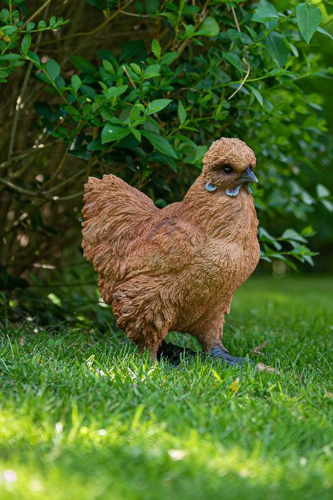 Eine hyperrealistische Statue eines braunen Huhns, das in einem Garten steht Garden ID